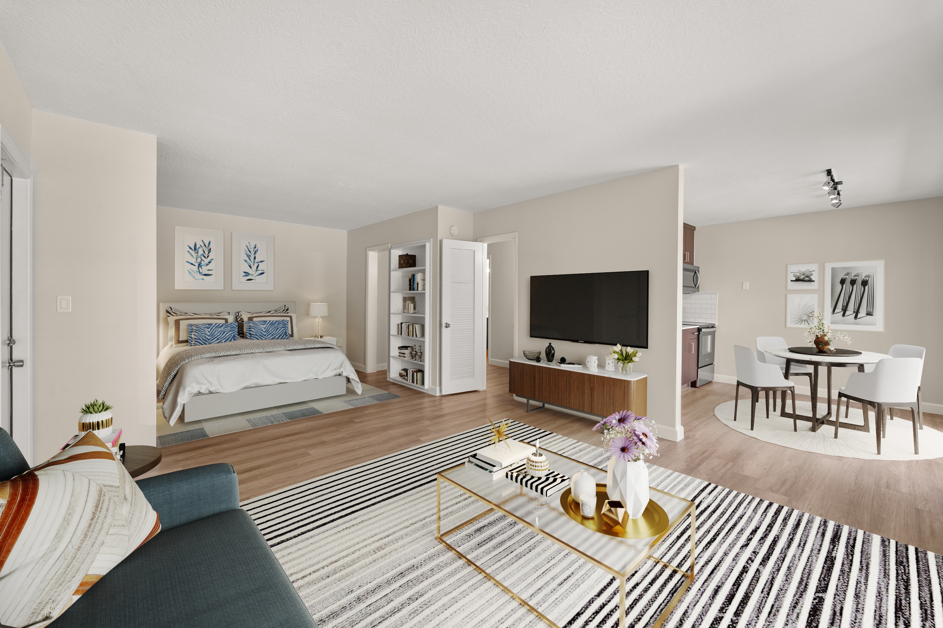 A living room with a grey sofa and a coffee table with a vase of flowers on it.